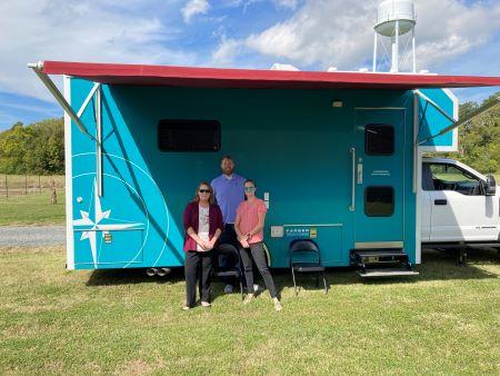 Three members of the Bay Rivers Telehealth Alliance in front of a mobile van